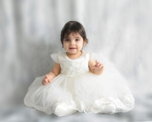 A smaller image of a young girl in a white dress